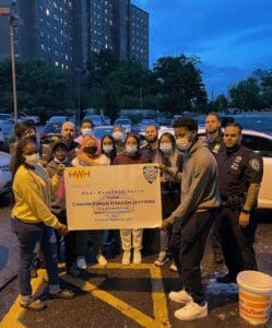 A group of people standing around each other holding up a large sign.