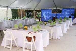 A large white tent with tables and chairs set up for an event.