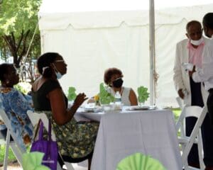 A group of people sitting at tables with plates.