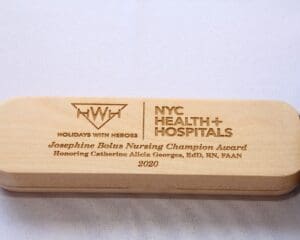 A wooden plaque with the words " nyc health & hospitals " on it.