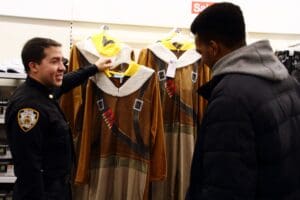 Two men standing in front of a row of dresses.