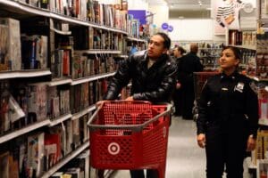 A man pushing a shopping cart in a store.