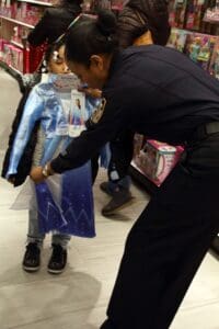 A police officer is helping a child dress up.