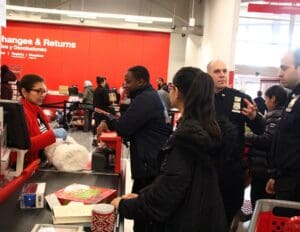 A group of people standing around in front of tables.