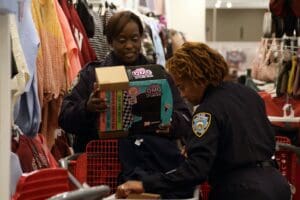 Two women in police uniforms looking at a book.