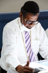 A man in white shirt and tie using a laptop.