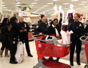 A group of people standing around a store with shopping carts.