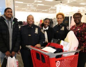 A group of people standing around a shopping cart.