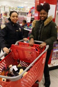 Two women are shopping at a store with their cart.