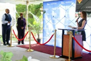 A man standing at the podium in front of a blue backdrop.