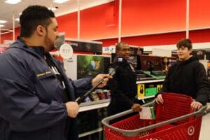 A man in uniform is holding two phones.