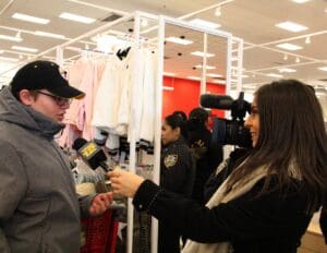 A woman is being interviewed by a man in a hat.