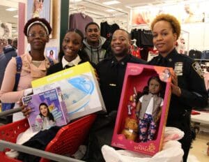 A group of people holding up boxes and dolls.