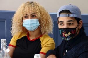 A man and woman wearing masks posing for the camera.