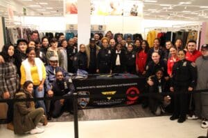 A group of people posing for a picture in front of a batman jacket.