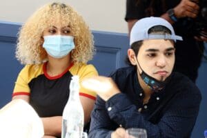 A man and woman wearing masks at a table.