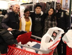 A group of people standing around a shopping cart.