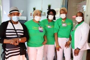 A group of people wearing masks and standing in a room.