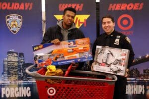 Two men standing next to a red shopping cart.