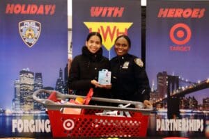 Two women in police uniforms holding a cell phone.