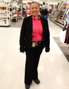 A woman in a black suit and pink shirt