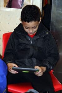 A young boy is playing on an ipad.