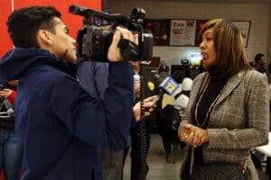 A man and woman are being interviewed by a camera.