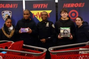 Three men in black jackets holding a shopping cart.