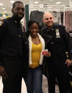 A woman posing with two police officers in uniform.