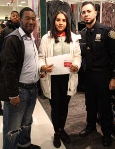 A woman standing between two men in police uniforms.