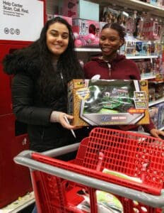 Two women are shopping at a store with their christmas gifts.