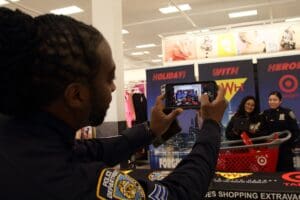 A man in police uniform taking a picture of another person.