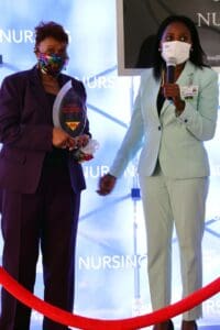 Two women standing next to each other holding a trophy.