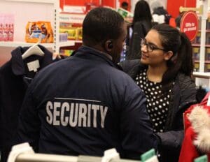 A security guard talking to a woman in a store.