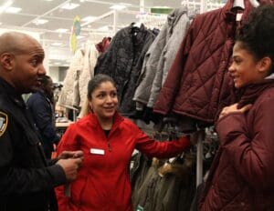 A woman is holding onto some jackets in the store