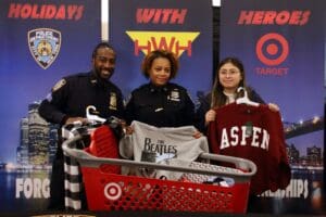 Three people in police uniforms holding a shopping basket.