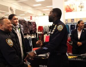 A man in police uniform talking to two people.