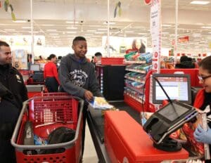 A man is standing at the checkout counter of a store.