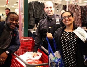 A group of people standing around in front of a shopping cart.