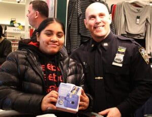 A police officer and girl holding a box of cookies.