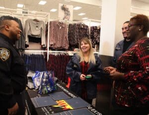 A group of people standing around in front of a table.