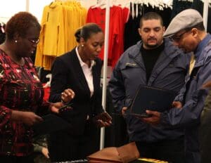 A group of people standing around looking at some items.