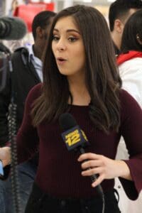 A woman is holding a microphone and talking.