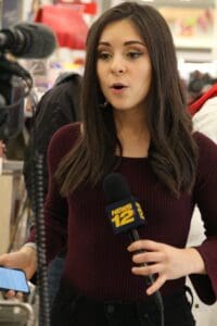 A woman is holding a microphone and talking.