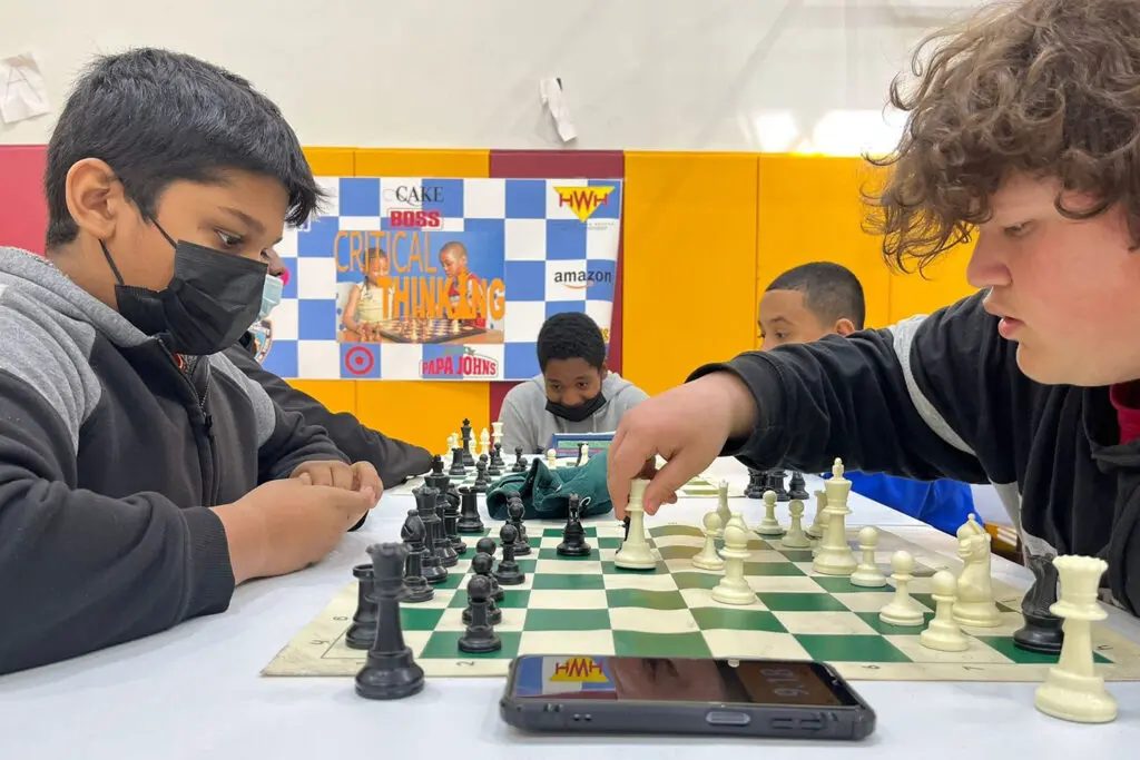 A group of people playing chess on a table.