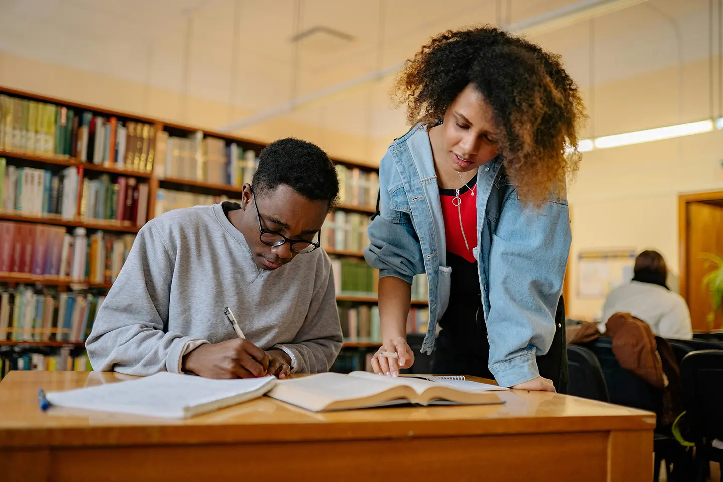 A woman helping a man with his homework.