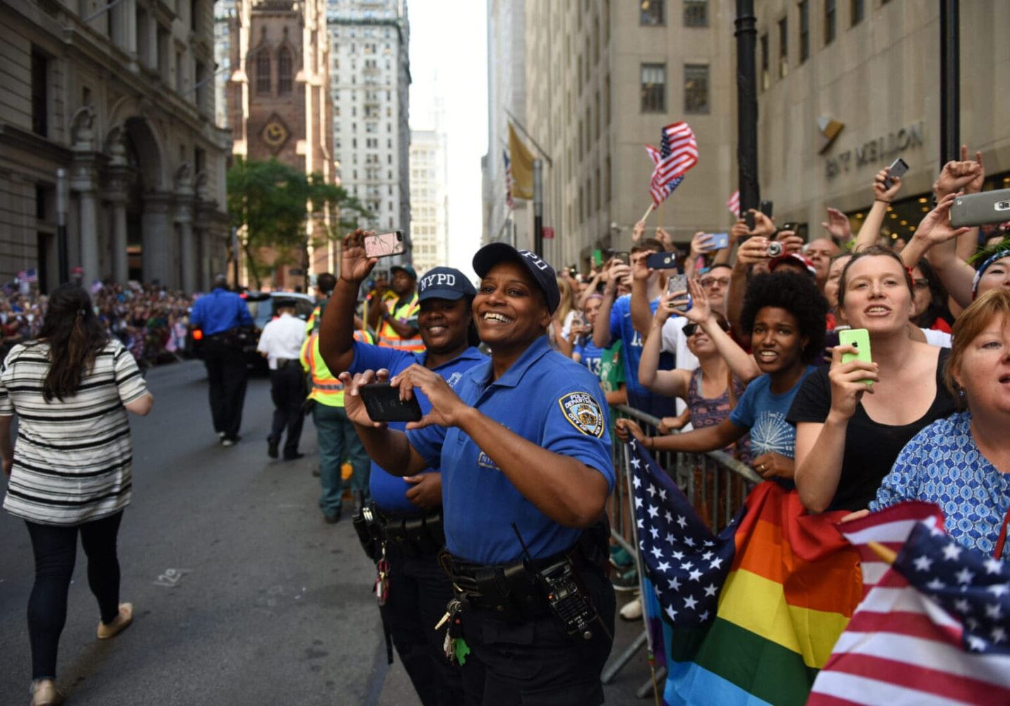 A group of people marching down the street with flags.